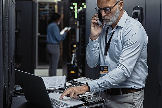 cybersecurity solutions asset with computer technician on phone in server room helping customer on phone